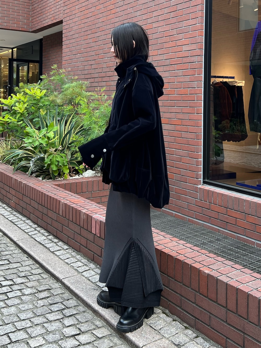 ブラック系のその他アウター、ブラック系のスカート、ブラック系のブーツを着用したレディースの秋コーディネートの2枚目の写真