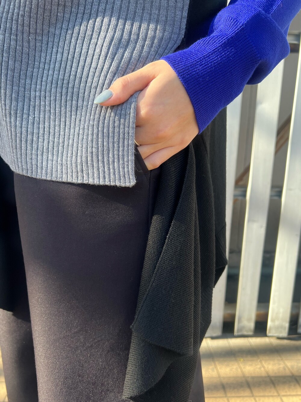 ブルー系のニット/セーター、ブラック系のその他パンツ、シルバー系のイヤリングを着用したレディースの冬コーディネートの8枚目の写真