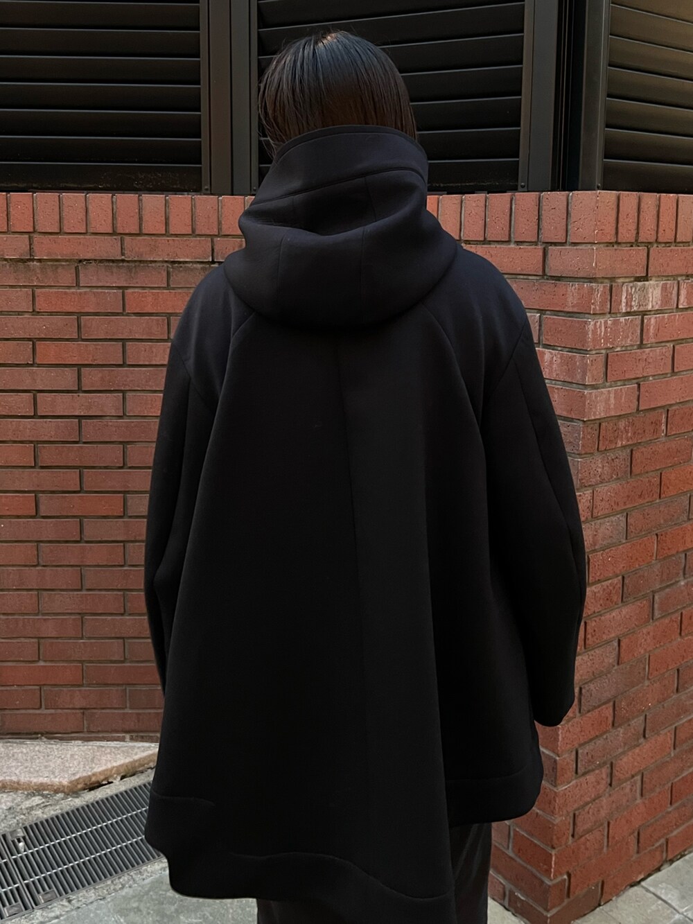 ブラック系のその他アウター、ブラック系のスカート、ブラック系のブーツを着用したレディースの秋コーディネートの5枚目の写真