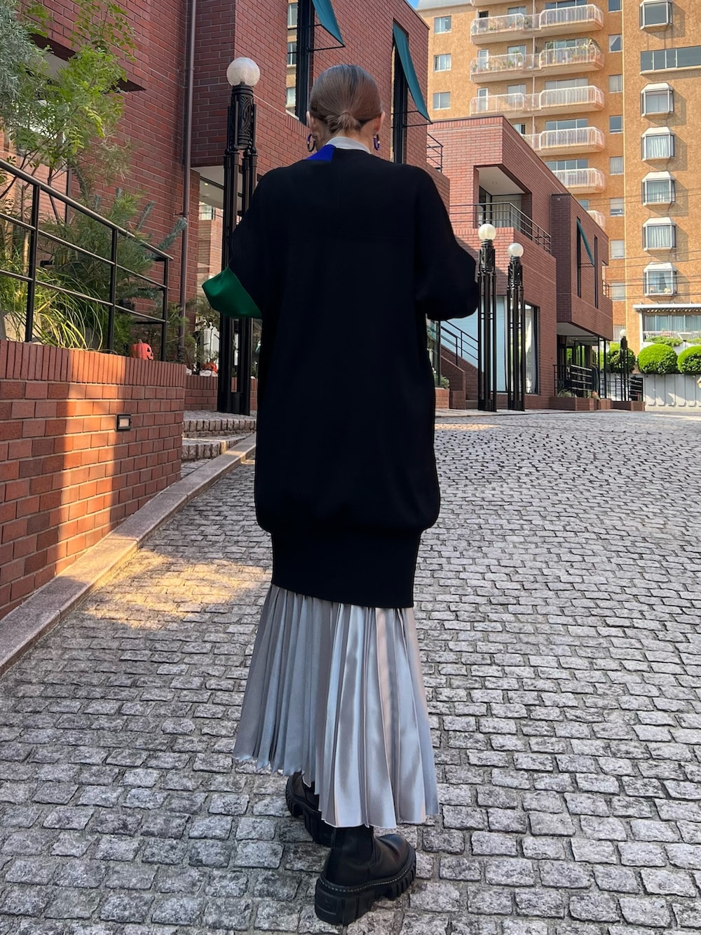 ブラック系のカーディガン/ボレロ、グレー系のニット/セーター、シルバー系のスカートを着用したレディースの秋コーディネートの2枚目の写真