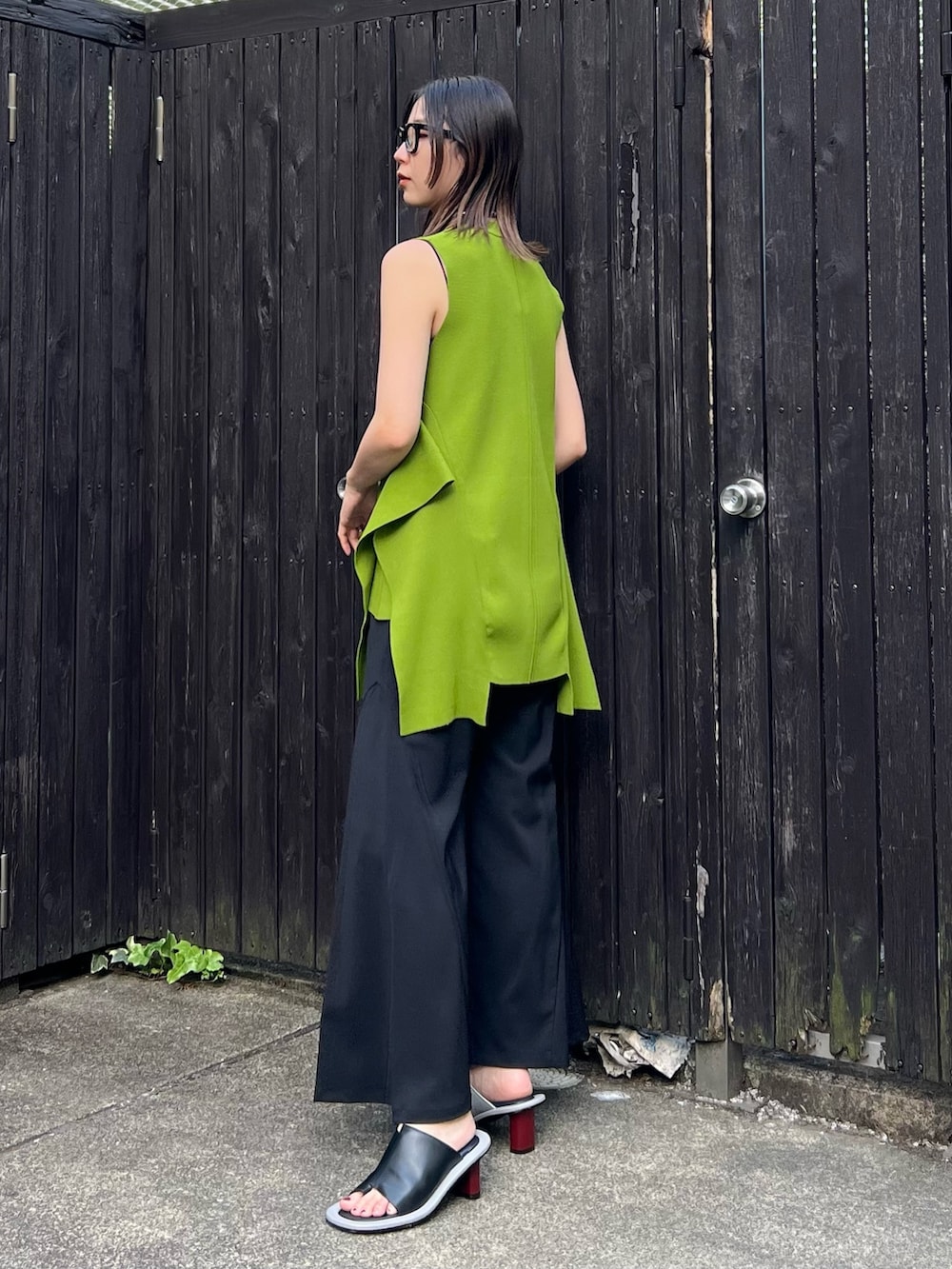 グリーン系のニット/セーター、ブラック系のその他パンツ、その他のサンダルを着用したレディースの春コーディネートの2枚目の写真