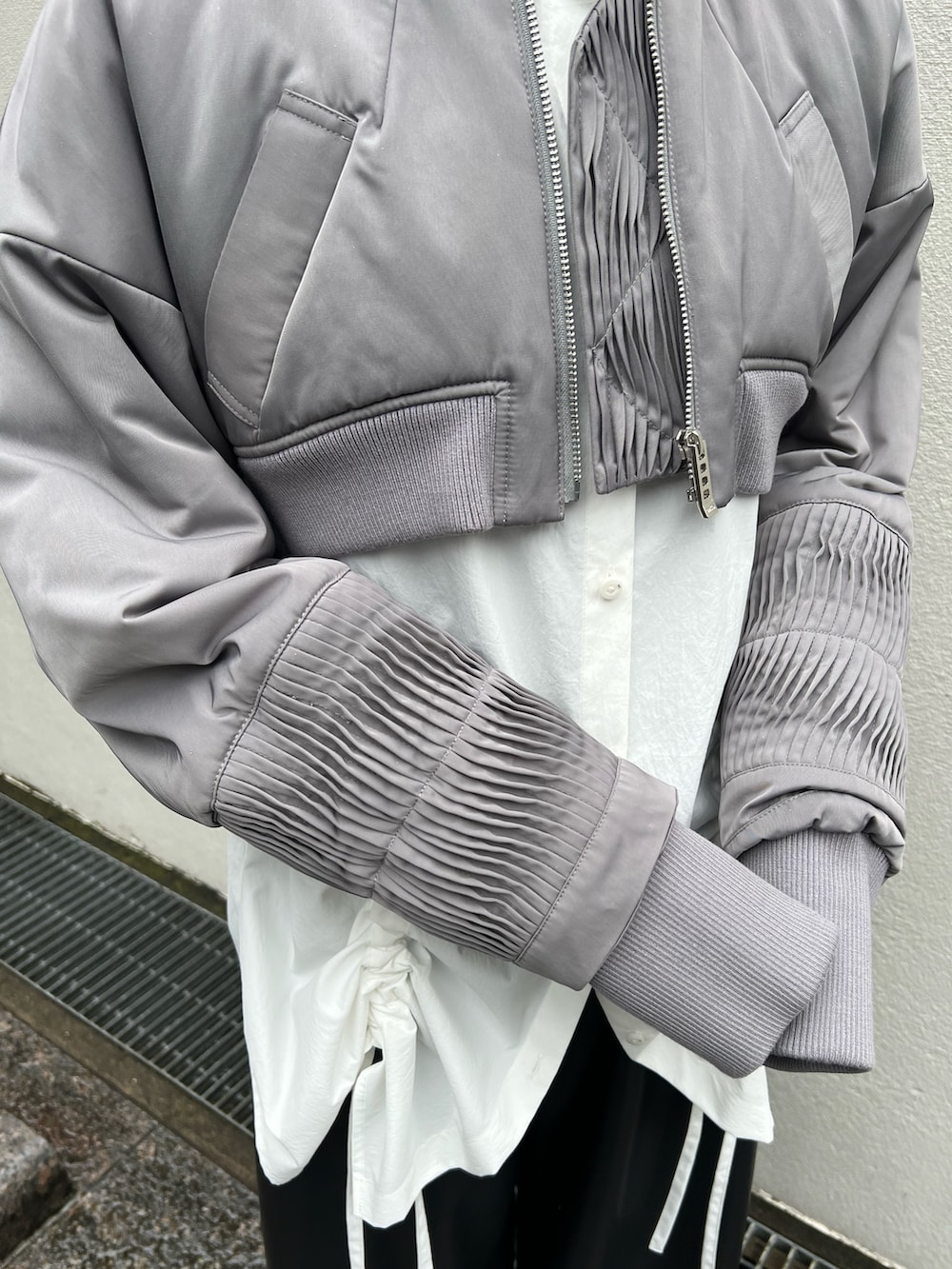 グレー系のブルゾン、ホワイト系のシャツ/ブラウス、ブラック系のその他パンツを着用したレディースの夏コーディネートの6枚目の写真