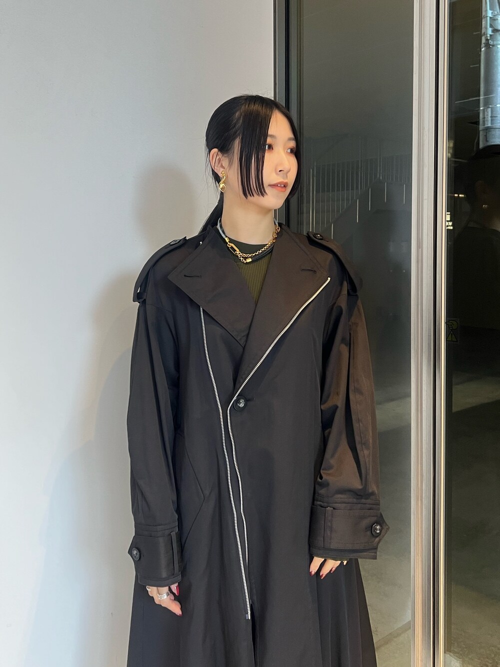 ブラック系のトレンチコート、ベージュ系のその他パンツ、ベージュ系のブーツを着用したレディースの冬コーディネートの3枚目の写真