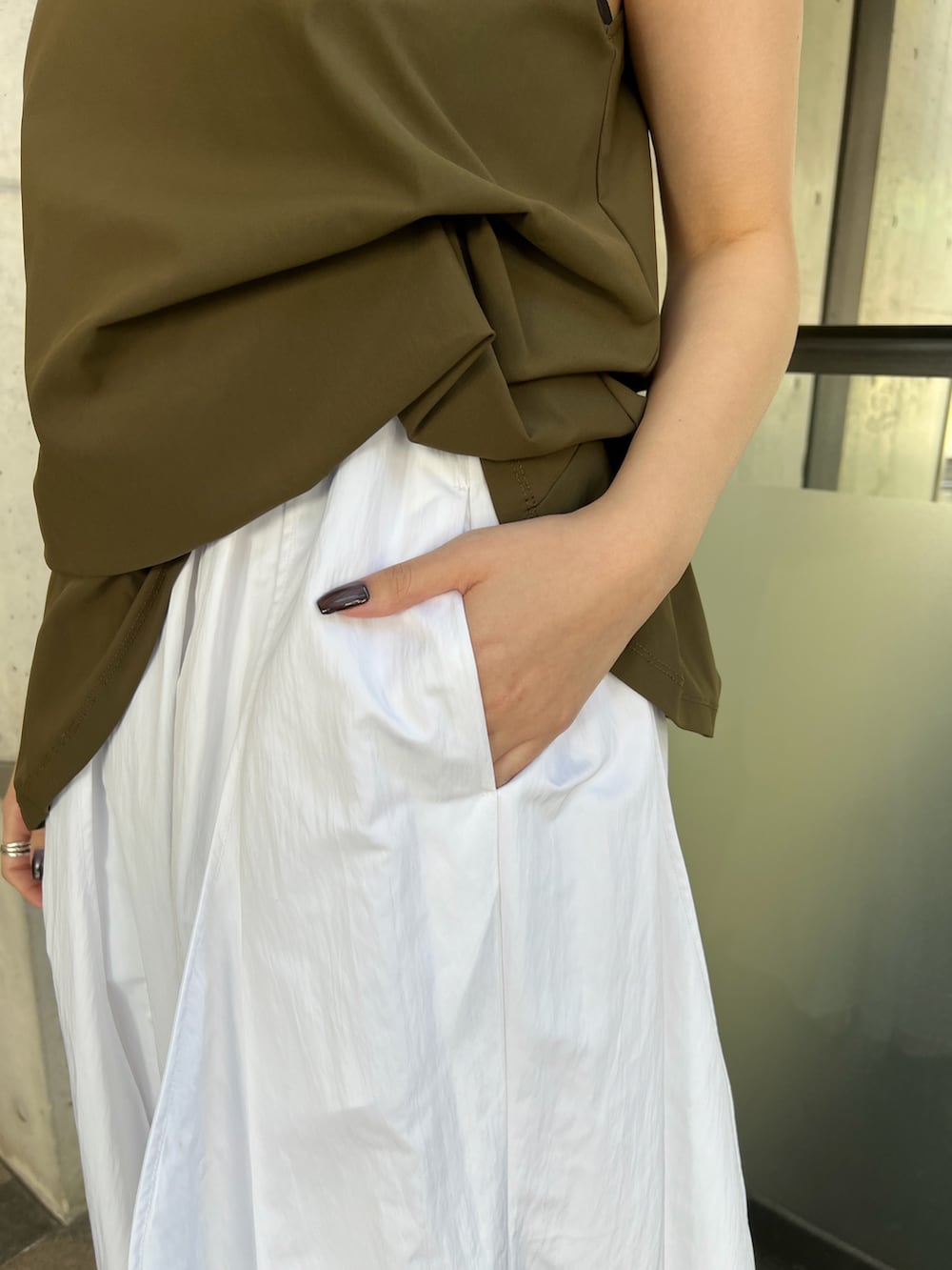 ホワイト系のワンピース、ブラック系のトートバッグ、シルバー系のサンダルを着用したレディースの春コーディネートの6枚目の写真