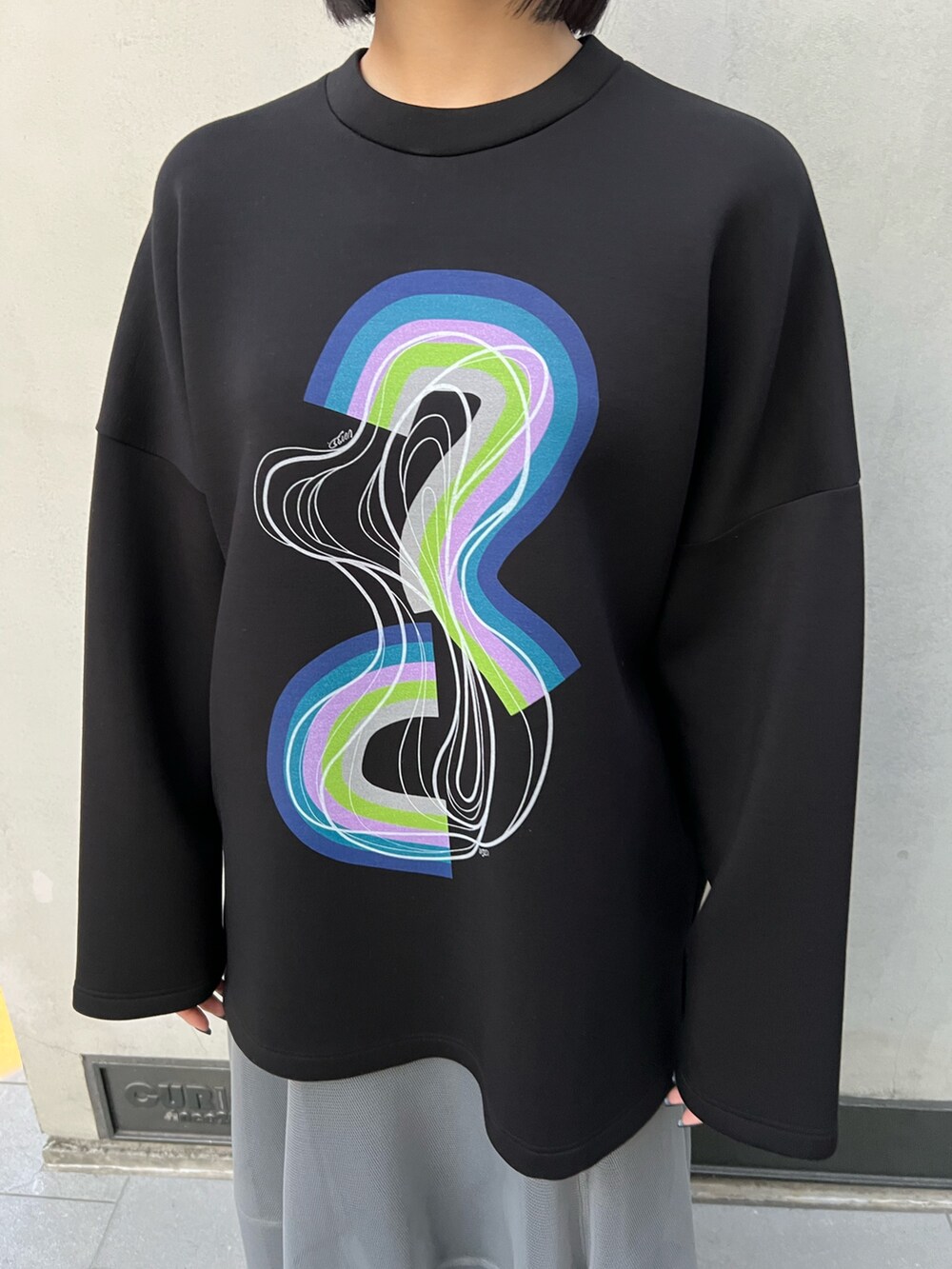 ブラック系のTシャツ/カットソー、グレー系のスカート、ブラック系のブーツを着用したレディースの冬コーディネートの5枚目の写真