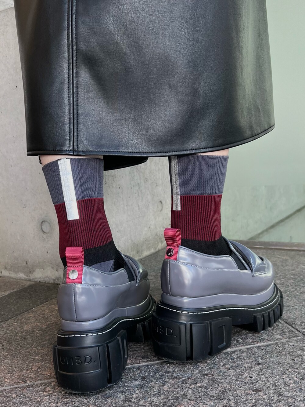 ブラック系のワンピース、グレー系のローファー、レッド系のハンドバッグを着用したレディースの夏コーディネートの6枚目の写真