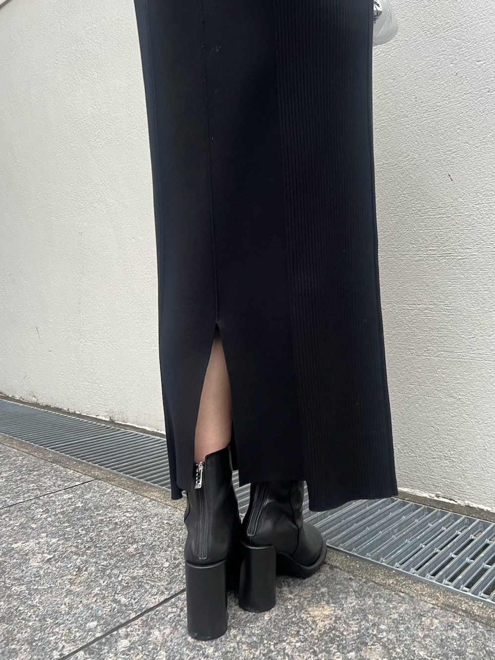 ブラック系のワンピース、シルバー系のハンドバッグ、ブラック系のブーツを着用したレディースの秋コーディネートの8枚目の写真