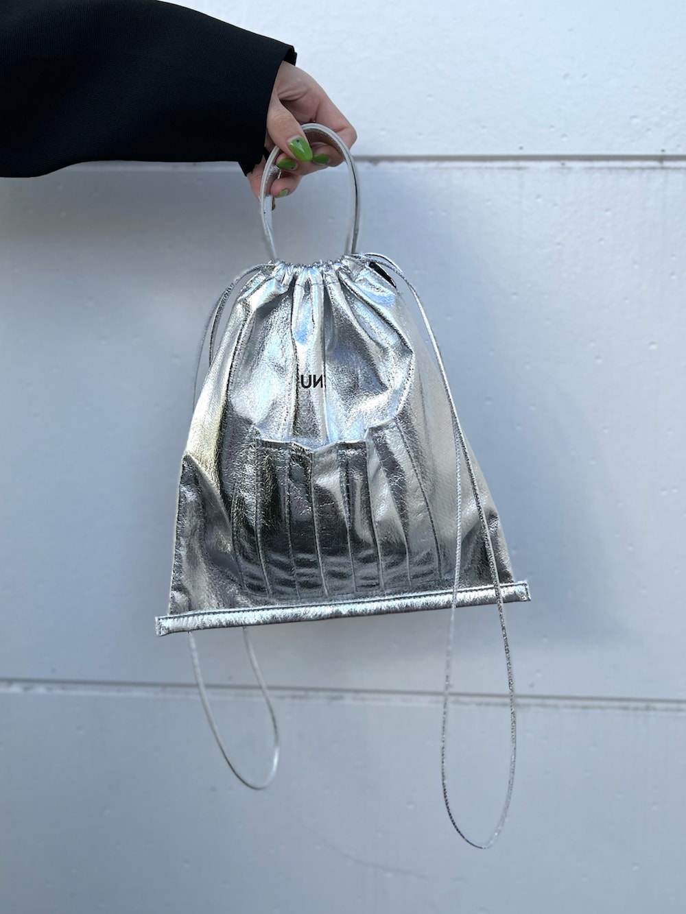 ブラック系のカーディガン/ボレロ、ベージュ系のワンピース、シルバー系のショルダーバッグを着用したレディースの春コーディネートの9枚目の写真