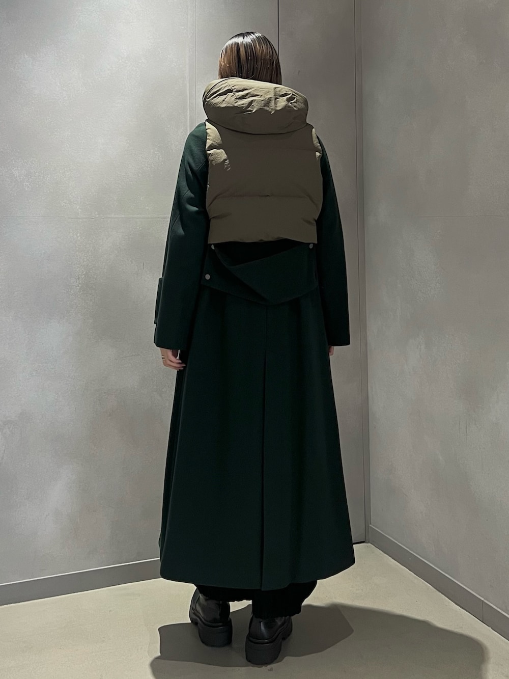 グリーン系のダウンベスト、グリーン系のその他アウター、シルバー系のイヤリングを着用したレディースの秋コーディネートの3枚目の写真