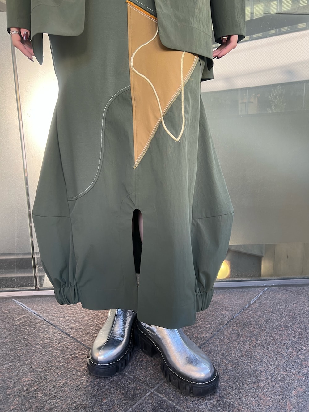 グリーン系のシャツ/ブラウス、グリーン系のスカート、シルバー系のブーツを着用したレディースの冬コーディネートの6枚目の写真