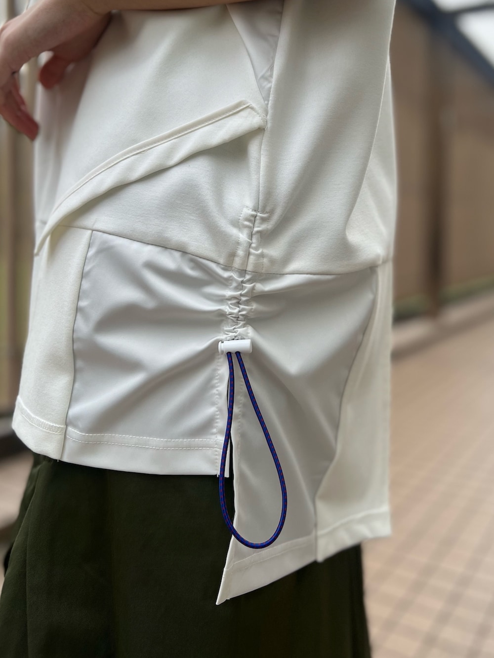 ホワイト系のTシャツ/カットソー、グリーン系のスカート、レッド系のトートバッグを着用したレディースの春コーディネートの5枚目の写真