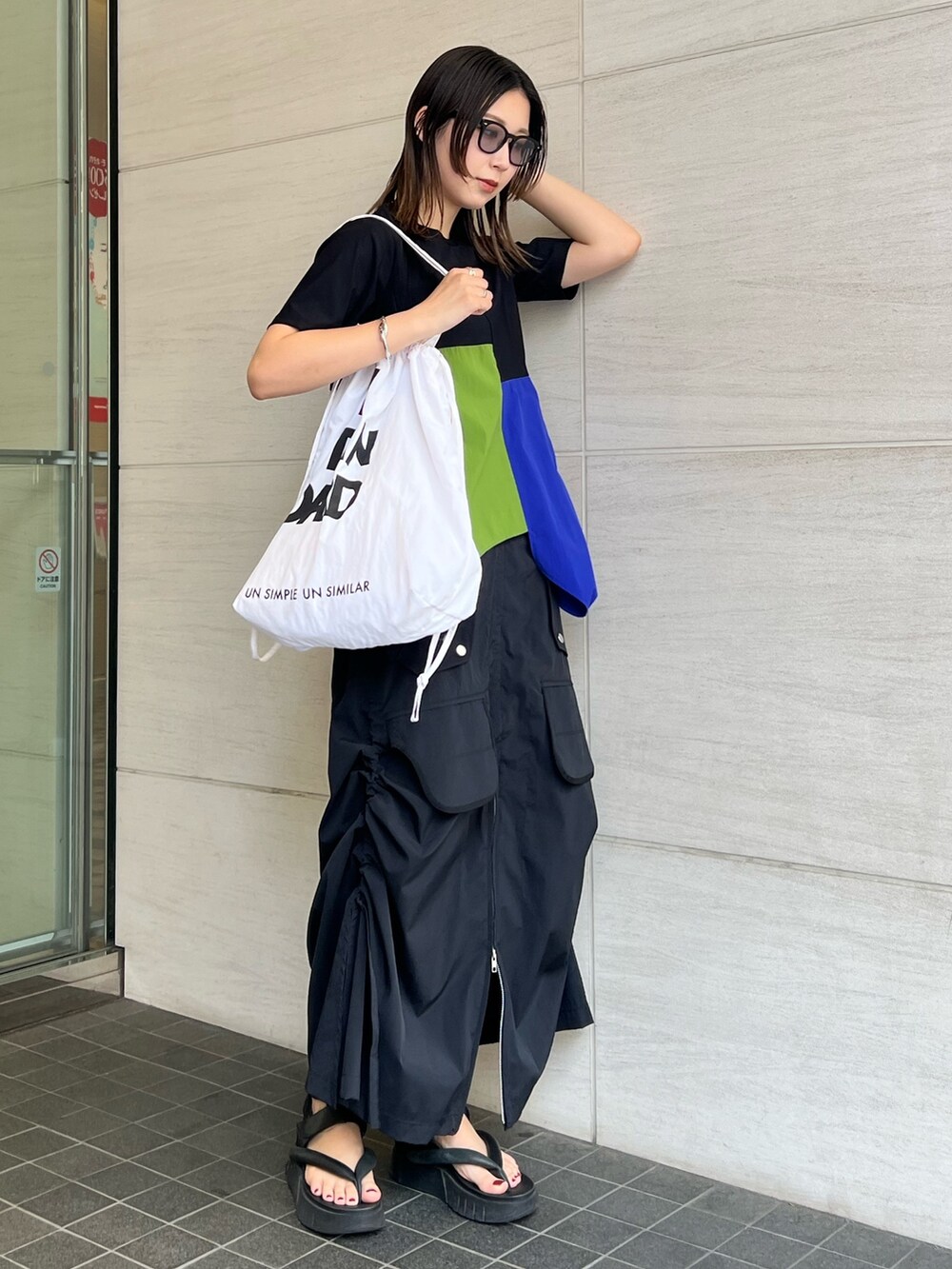 その他のTシャツ/カットソー、ブラック系のスカート、ブラック系のサングラスを着用したレディースの春コーディネートの2枚目の写真