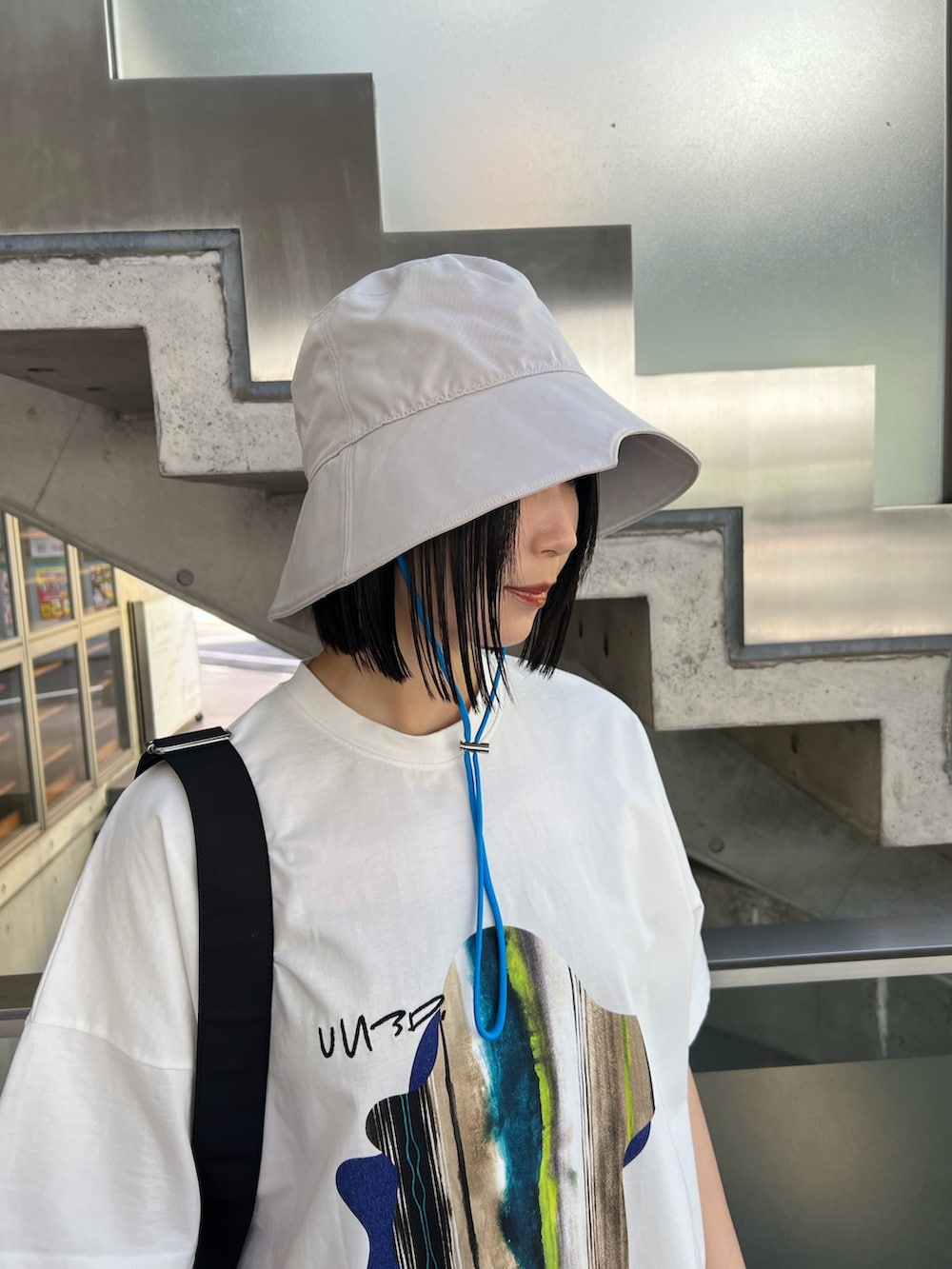 ホワイト系のTシャツ/カットソー、ブラック系のスカート、ブラック系のボディバッグ/ウエストポーチを着用したレディースの春コーディネートの5枚目の写真