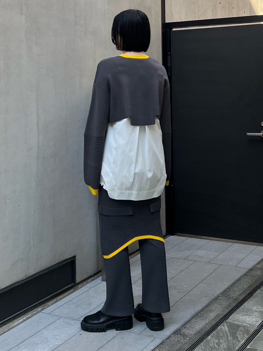 グレー系のその他パンツ、グレー系のニット/セーター、ホワイト系のシャツ/ブラウスを着用したレディースの夏コーディネートの2枚目の写真