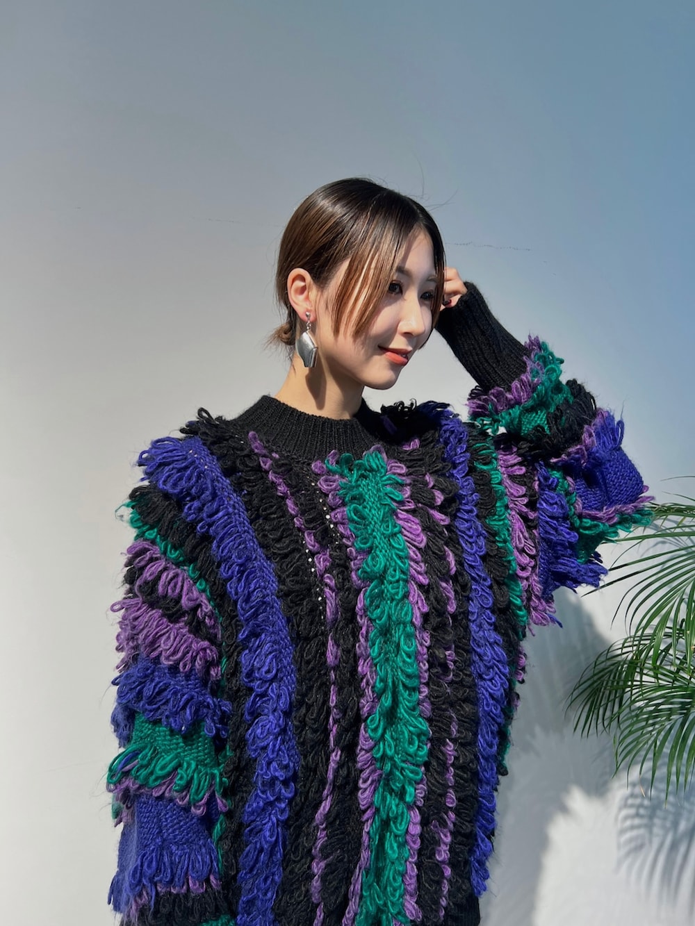 パープル系のニット/セーター、ブラック系のその他パンツ、ブラック系のブーツを着用したレディースの秋コーディネートの3枚目の写真