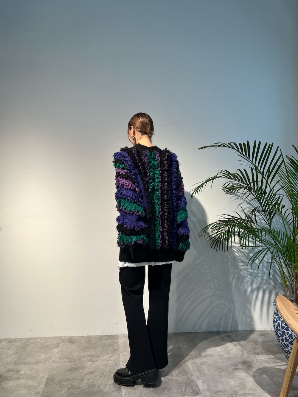 パープル系のニット/セーター、ブラック系のその他パンツ、ブラック系のブーツを着用したレディースの秋コーディネートの2枚目の写真