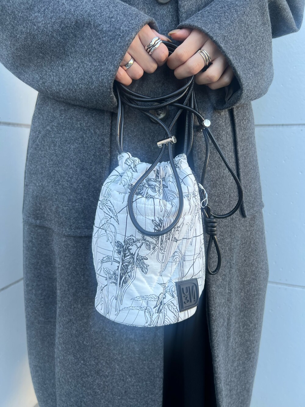 グレー系のその他アウター、ホワイト系のショルダーバッグ、ブラック系のブーツを着用したレディースの冬コーディネートの4枚目の写真