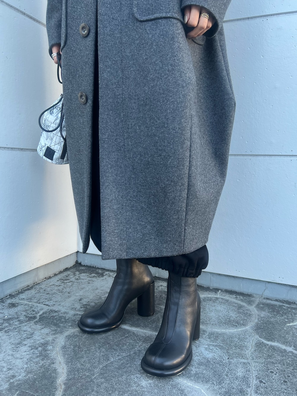 グレー系のその他アウター、ホワイト系のショルダーバッグ、ブラック系のブーツを着用したレディースの冬コーディネートの9枚目の写真