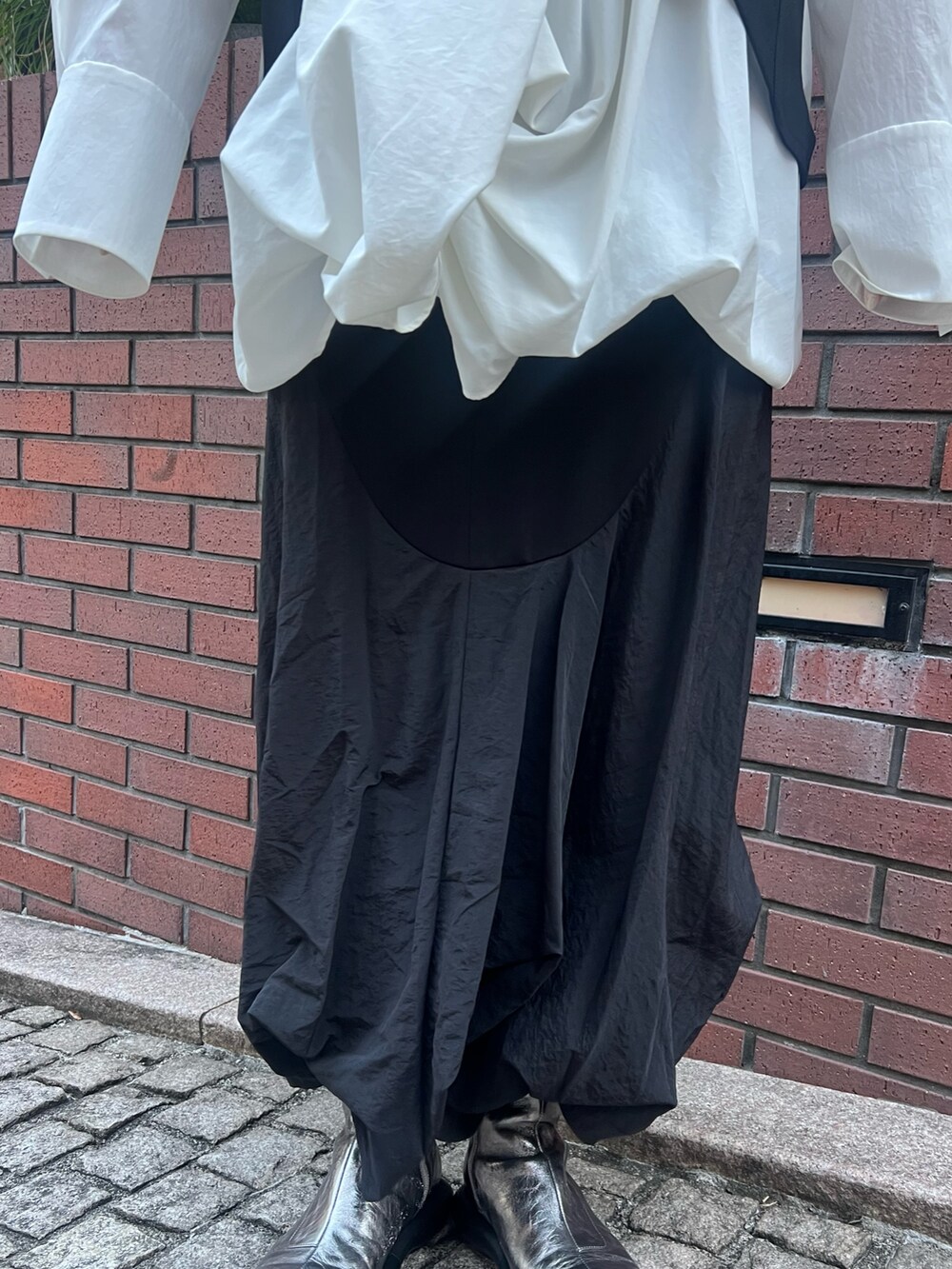 ブラック系のキャミソール、ホワイト系のシャツ/ブラウス、ブラック系のスカートを着用したレディースの冬コーディネートの6枚目の写真