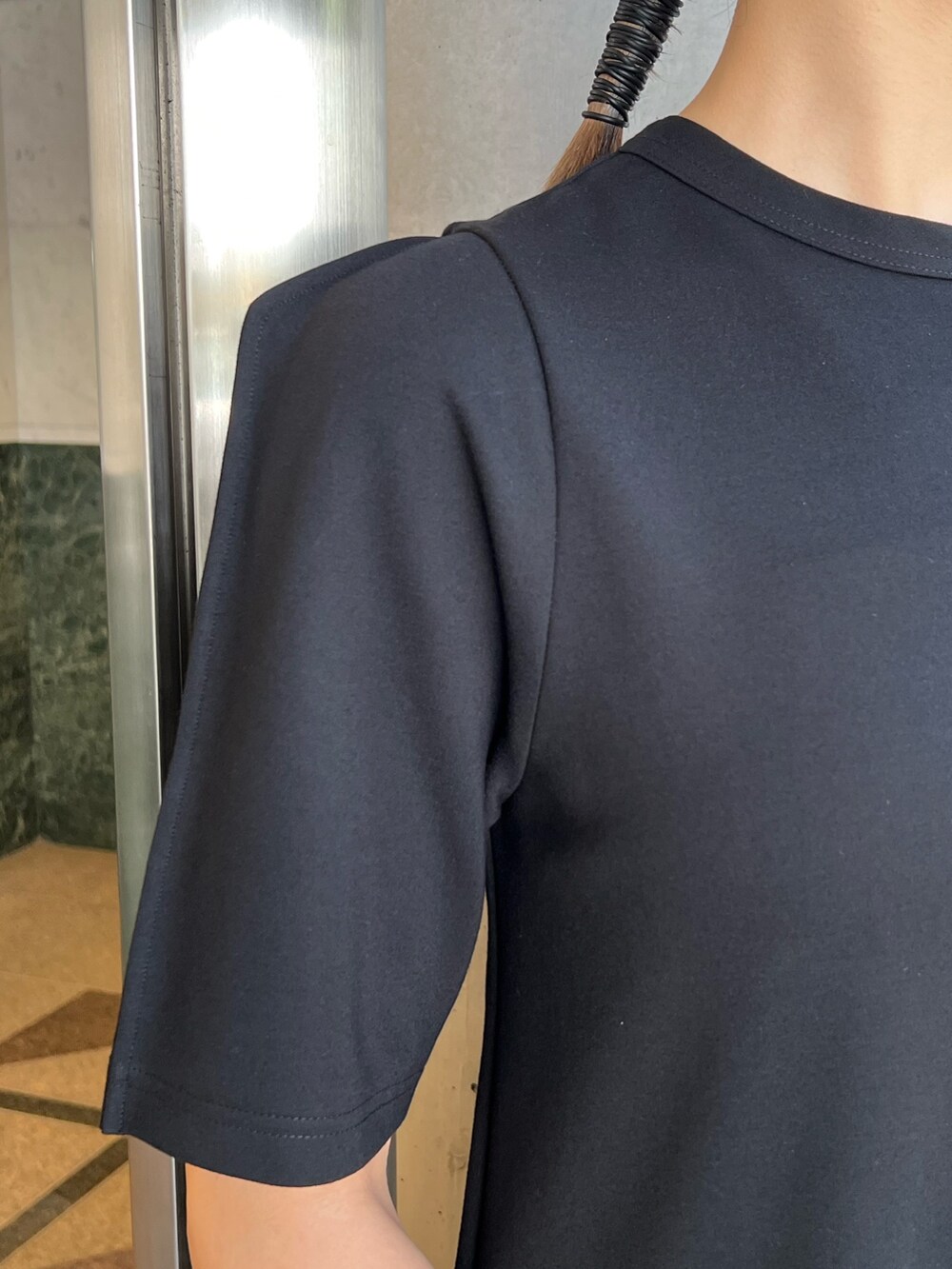 ブラック系のワンピース、グレー系のローファー、レッド系のハンドバッグを着用したレディースの夏コーディネートの4枚目の写真