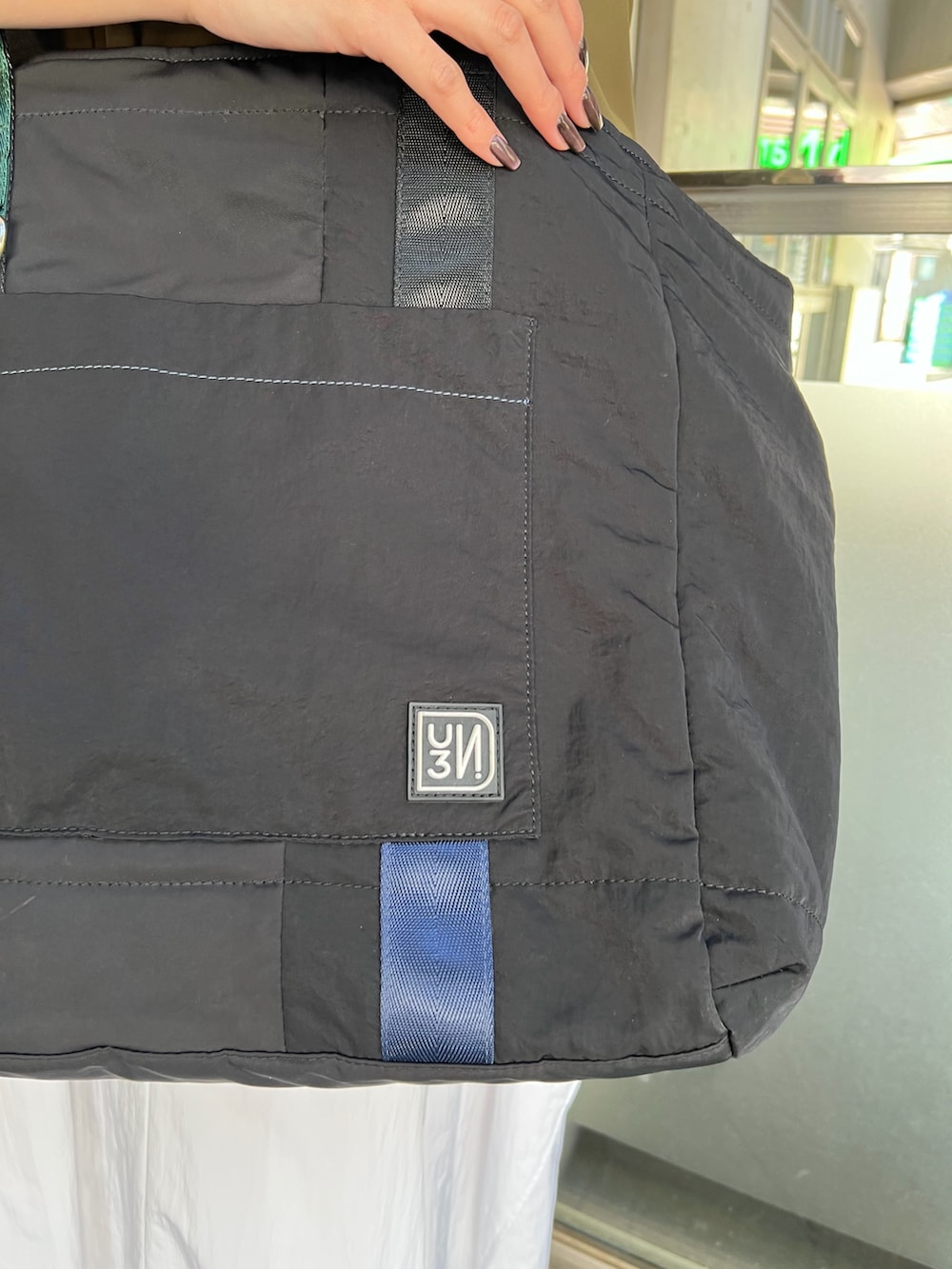 ホワイト系のワンピース、ブラック系のトートバッグ、シルバー系のサンダルを着用したレディースの春コーディネートの5枚目の写真