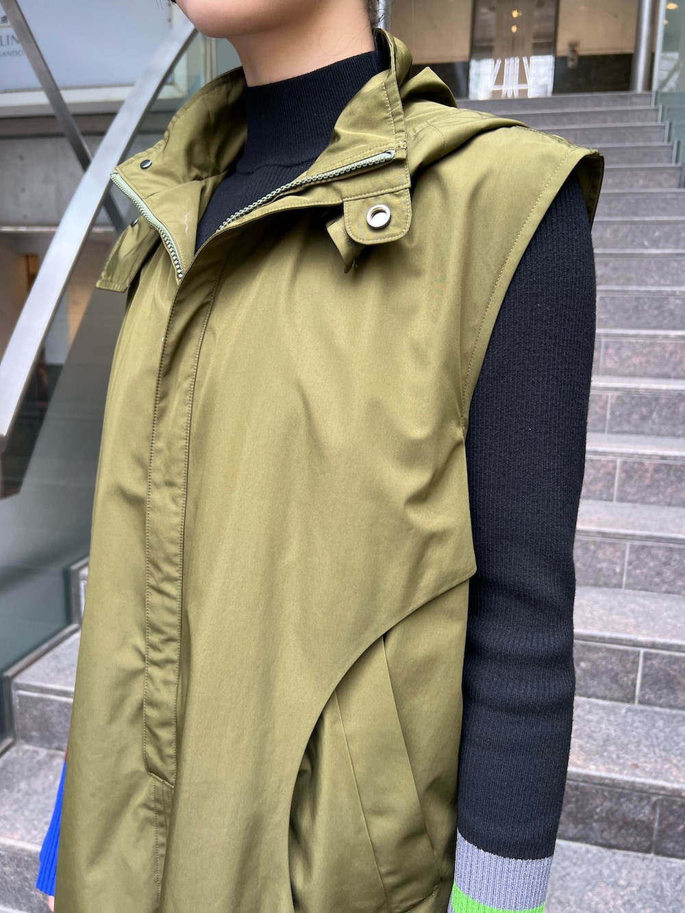 グリーン系のワンピース、ブラック系のスニーカー、ブラック系のニット/セーターを着用したレディースの秋コーディネートの5枚目の写真