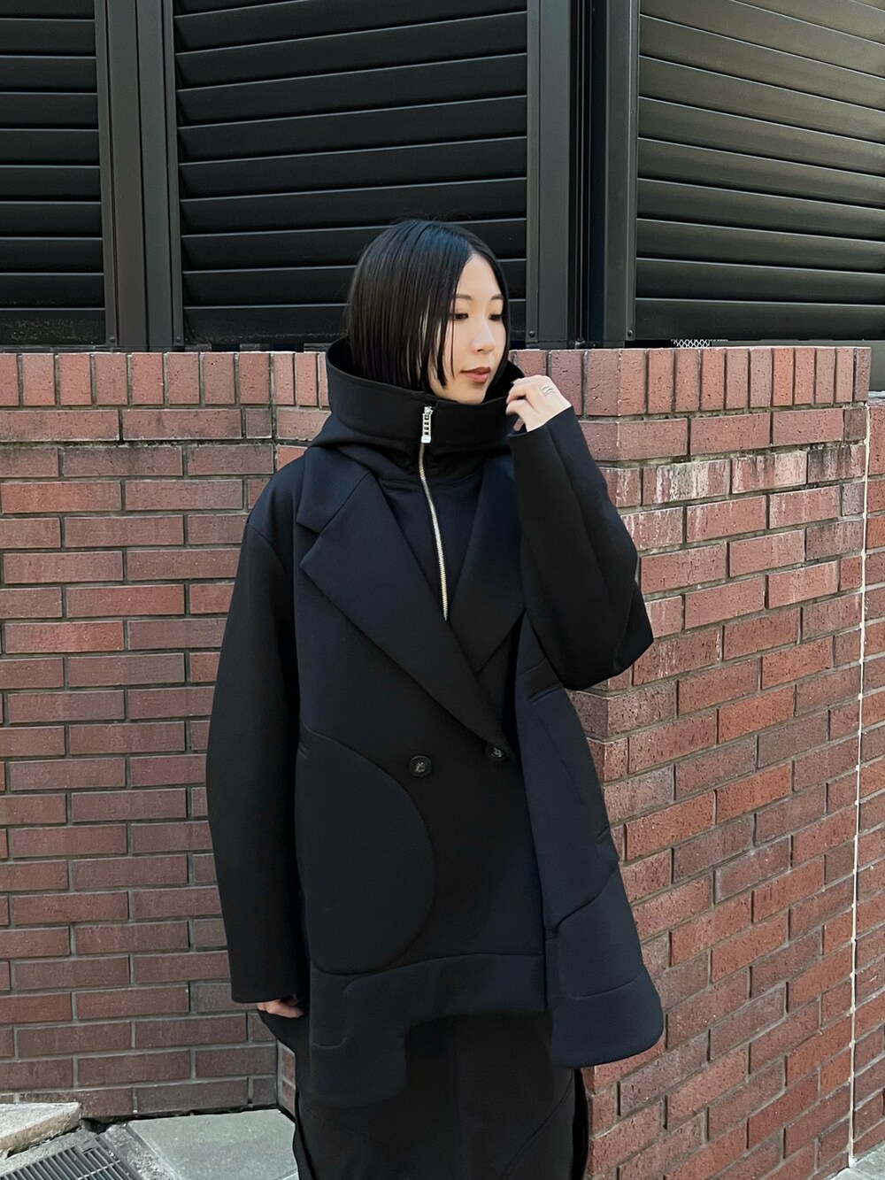 ブラック系のその他アウター、ブラック系のスカート、ブラック系のブーツを着用したレディースの秋コーディネートの3枚目の写真