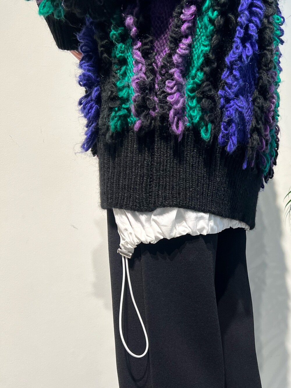 パープル系のニット/セーター、ブラック系のその他パンツ、ブラック系のブーツを着用したレディースの秋コーディネートの4枚目の写真