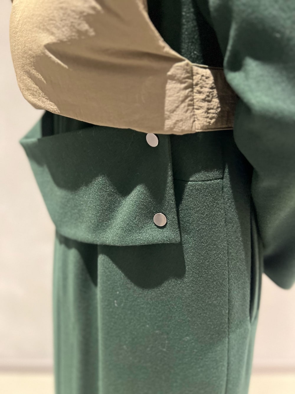 グリーン系のダウンベスト、グリーン系のその他アウター、シルバー系のイヤリングを着用したレディースの秋コーディネートの7枚目の写真