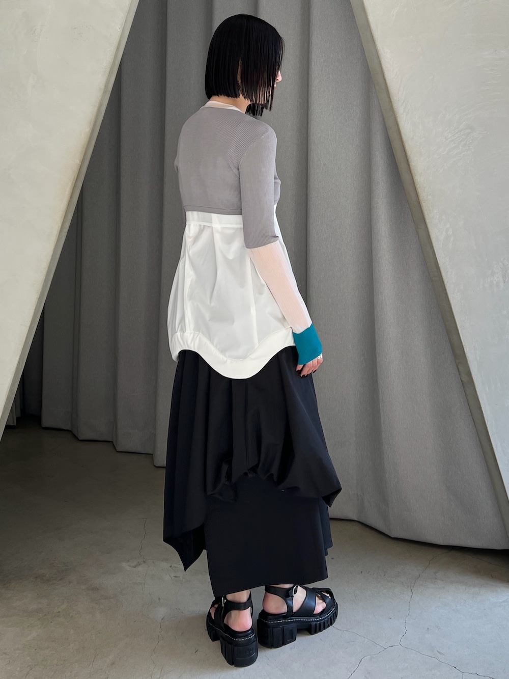 ホワイト系のタンクトップ、グレー系のカーディガン/ボレロ、ブラック系のその他パンツを着用したレディースの春コーディネートの2枚目の写真