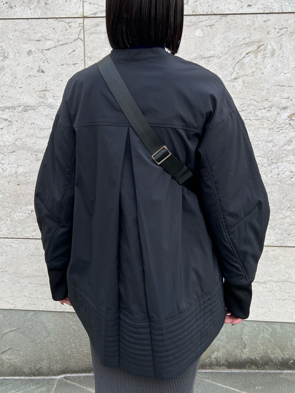 ブラック系のシャツ/ブラウス、パープル系のニット/セーター、ブラック系のスカートを着用したレディースの秋コーディネートの6枚目の写真