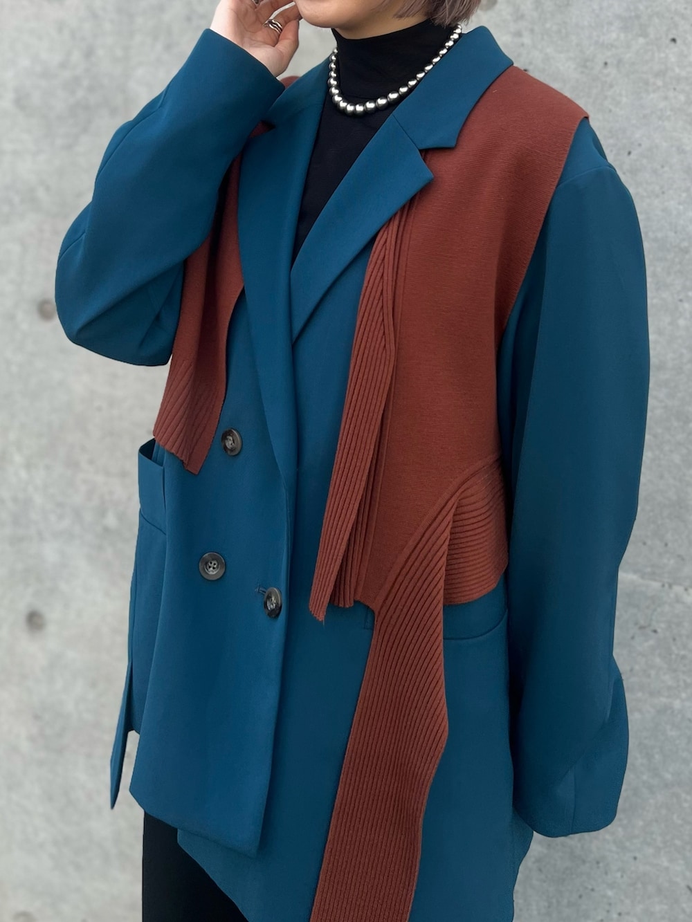 ブルー系のテーラードジャケット、ブラック系のその他パンツ、ブラック系のブーツを着用したレディースの秋コーディネートの3枚目の写真