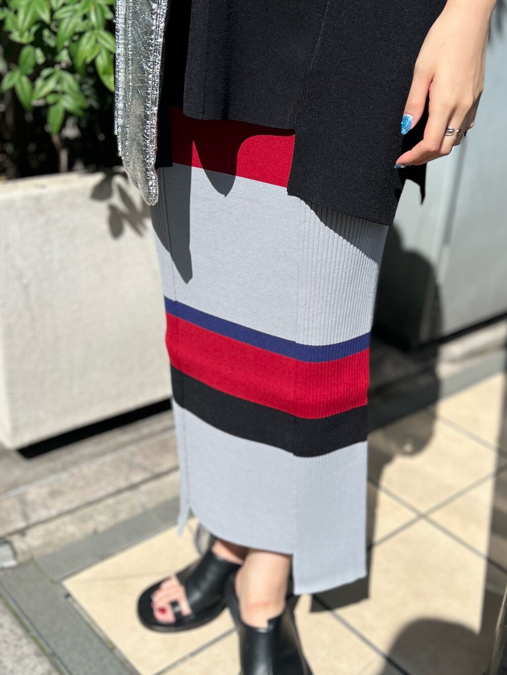 ブラック系のニット/セーター、ブラック系のスカート、シルバー系のトートバッグを着用したレディースの夏コーディネートの6枚目の写真