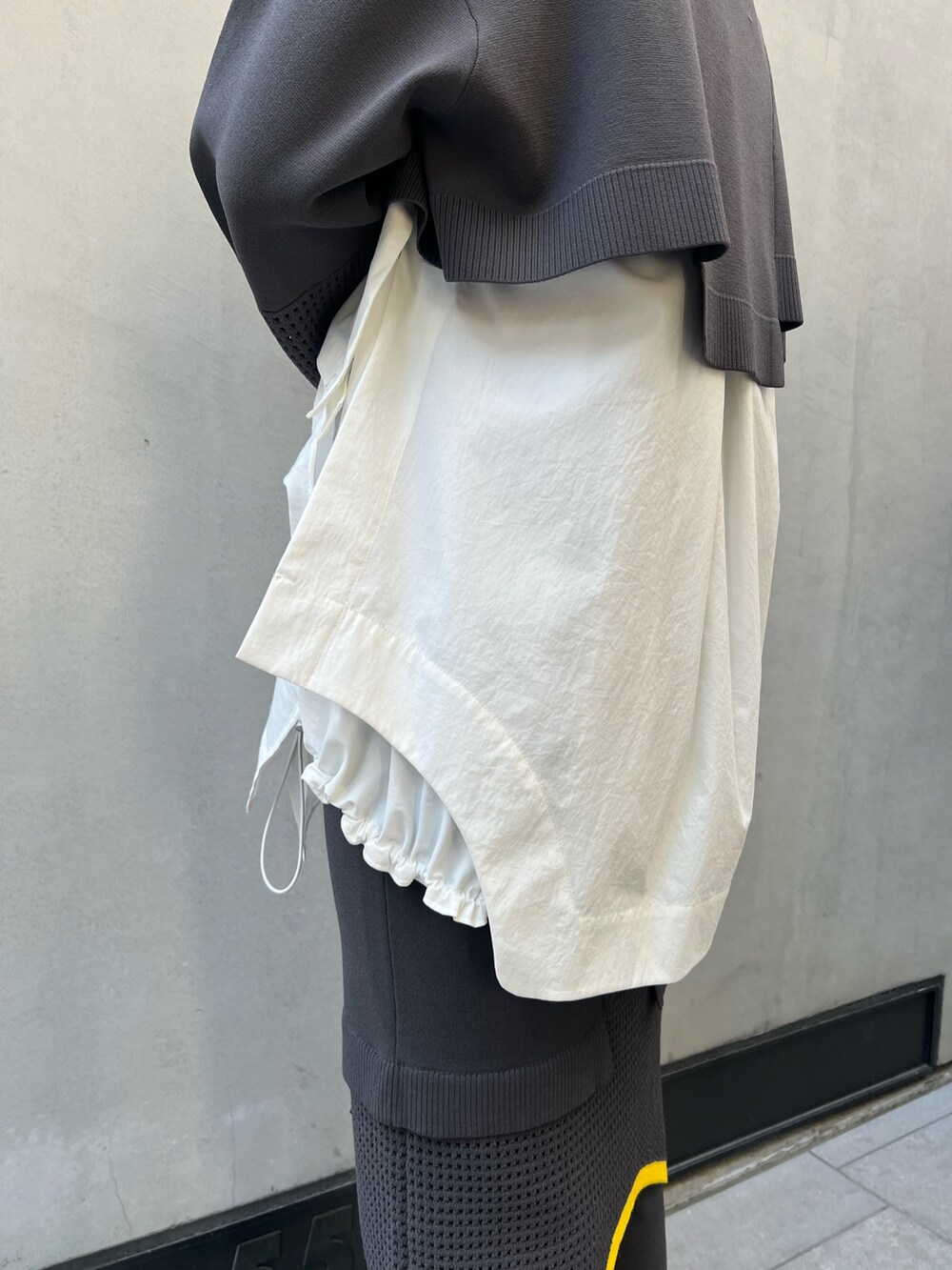 グレー系のその他パンツ、グレー系のニット/セーター、ホワイト系のシャツ/ブラウスを着用したレディースの夏コーディネートの6枚目の写真