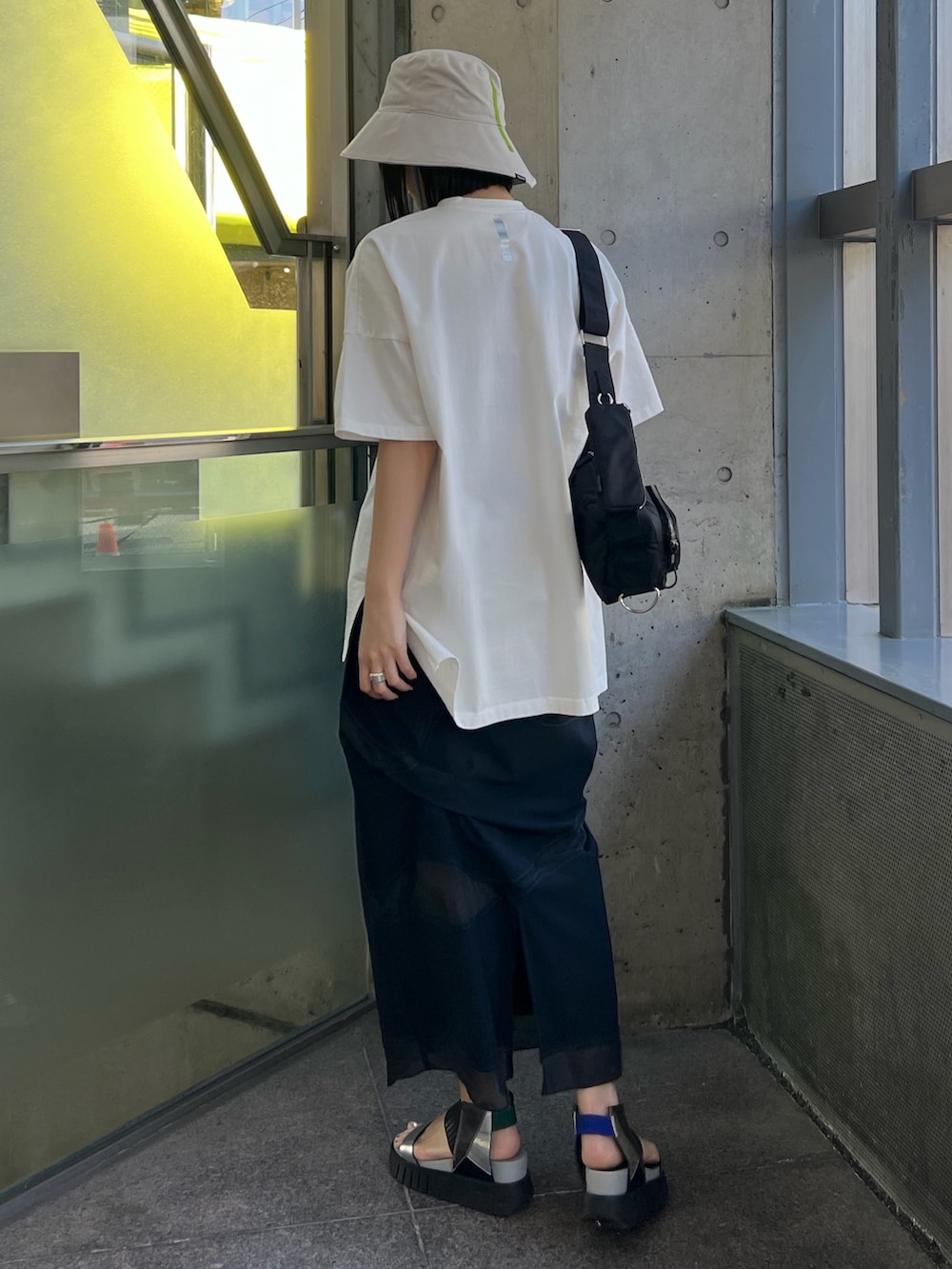 ホワイト系のTシャツ/カットソー、ブラック系のスカート、ブラック系のボディバッグ/ウエストポーチを着用したレディースの春コーディネートの2枚目の写真