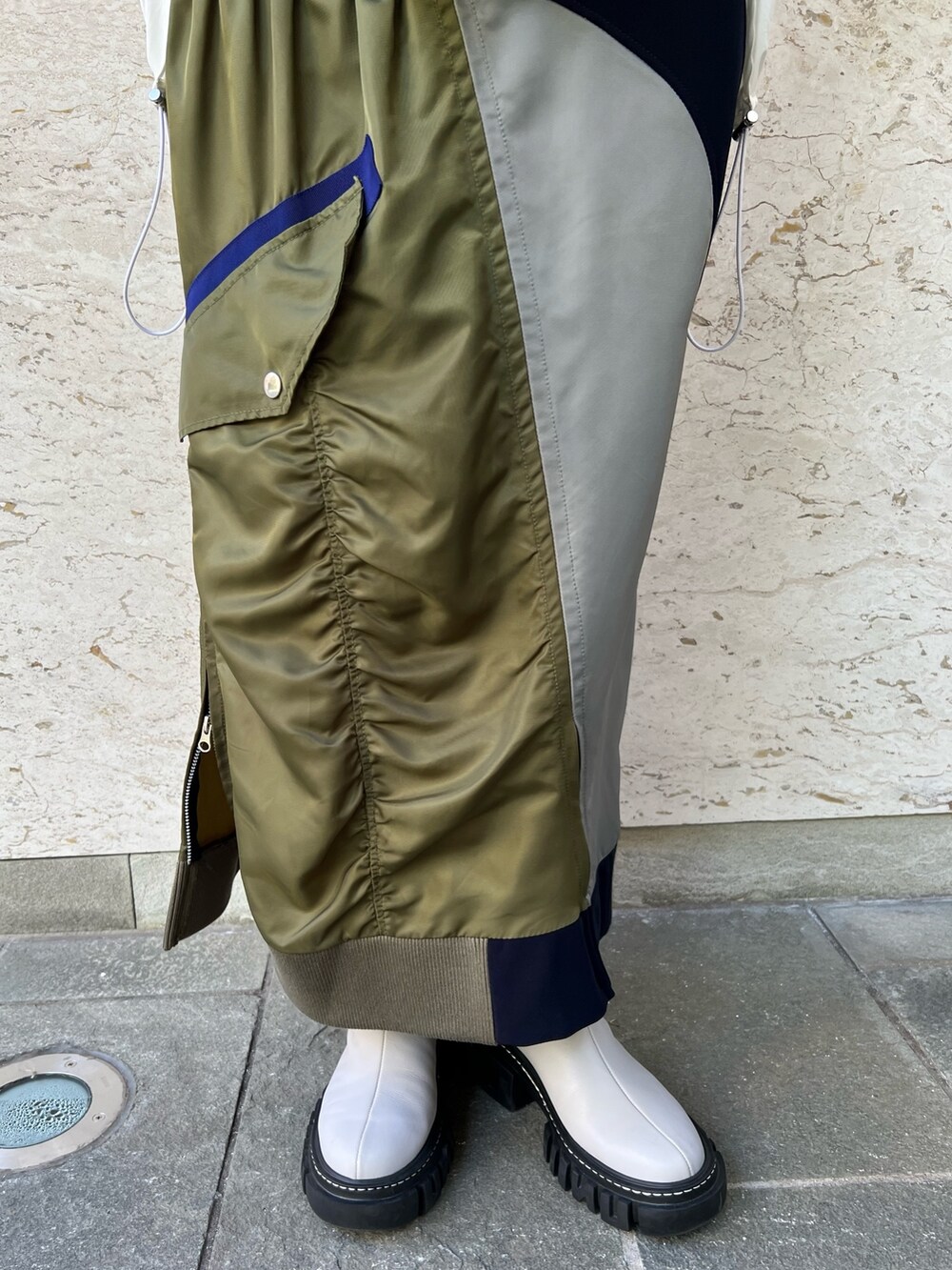 グレー系のニット/セーター、ホワイト系のシャツ/ブラウス、ブルー系のスカートを着用したレディースの秋コーディネートの7枚目の写真