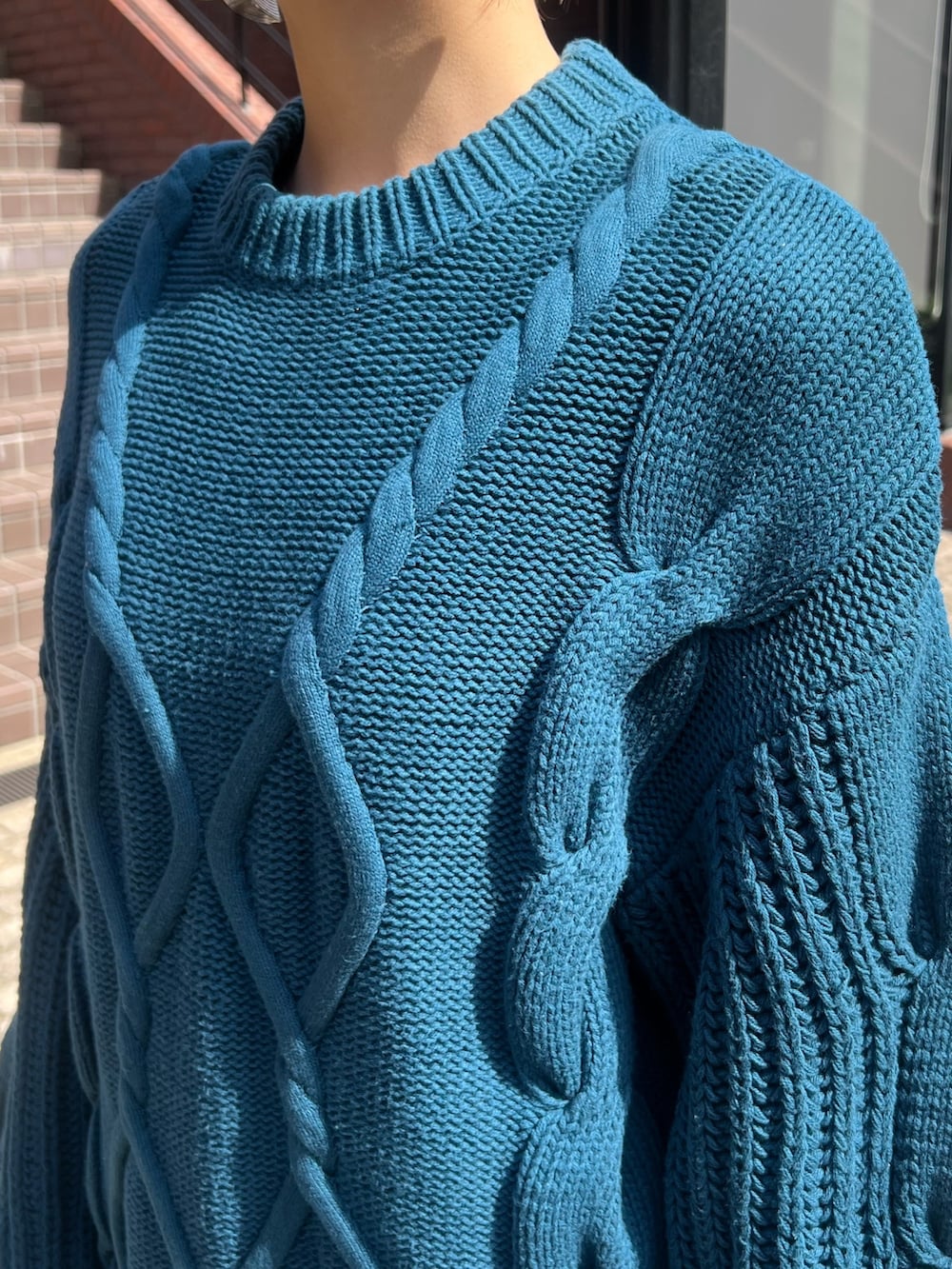 ブルー系のワンピース、ブラック系のブーツ、シルバー系のイヤリングを着用したレディースの秋コーディネートの4枚目の写真