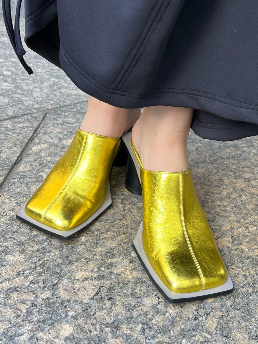 ブラック系のワンピース、ゴールド系のパンプス、ゴールド系のイヤリングを着用したレディースの冬コーディネートの7枚目の写真