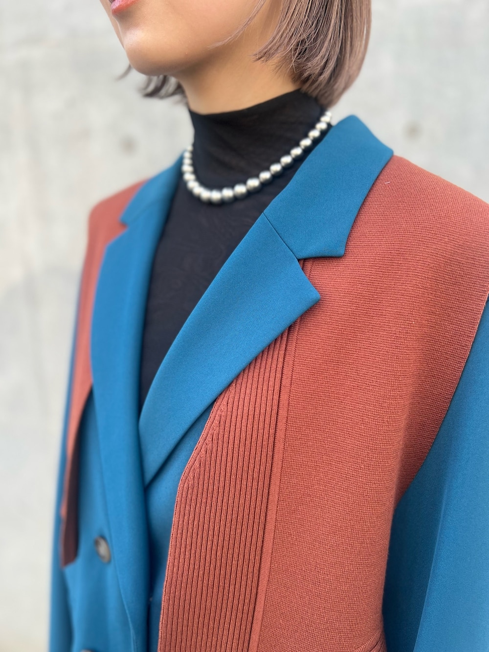 ブルー系のテーラードジャケット、ブラック系のその他パンツ、ブラック系のブーツを着用したレディースの秋コーディネートの5枚目の写真