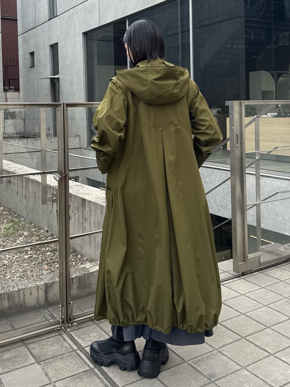 グリーン系のその他アウター、ブラック系のブーツを着用したレディースの冬コーディネートの2枚目の写真