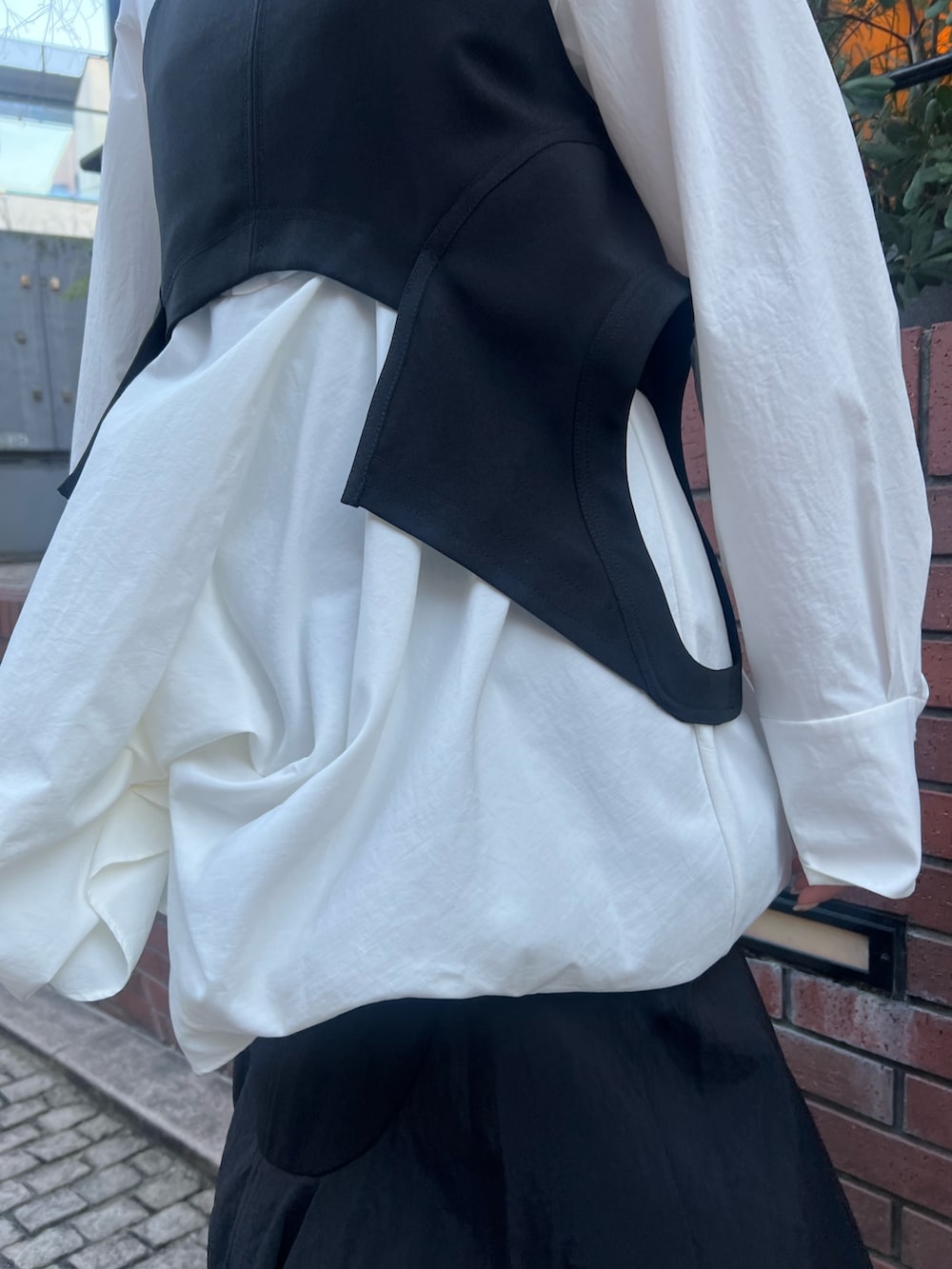 ブラック系のキャミソール、ホワイト系のシャツ/ブラウス、ブラック系のスカートを着用したレディースの冬コーディネートの5枚目の写真