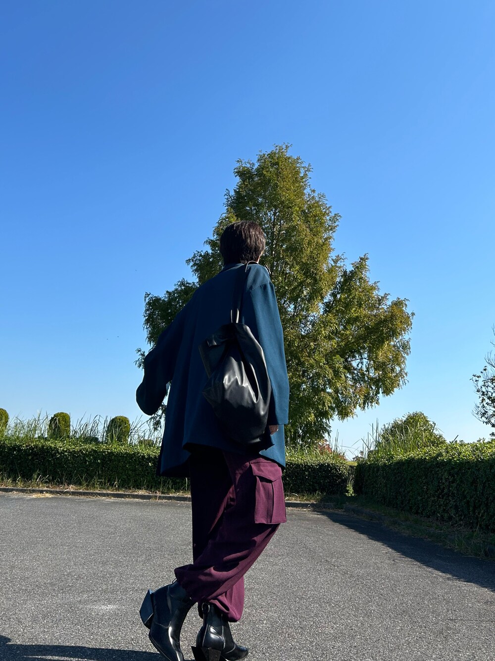 ブルー系のテーラードジャケット、レッド系のその他パンツ、ブラック系のブーツを着用したメンズの秋コーディネートの2枚目の写真