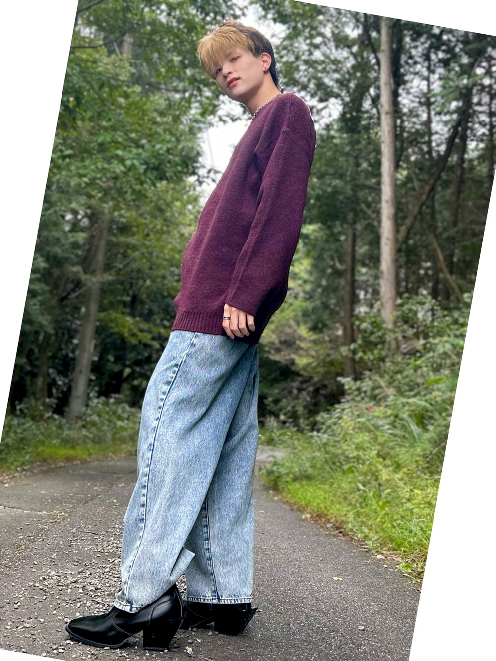 レッド系のニット/セーター、ブルー系のデニムパンツ、ブラック系のブーツを着用したメンズの秋コーディネートの2枚目の写真