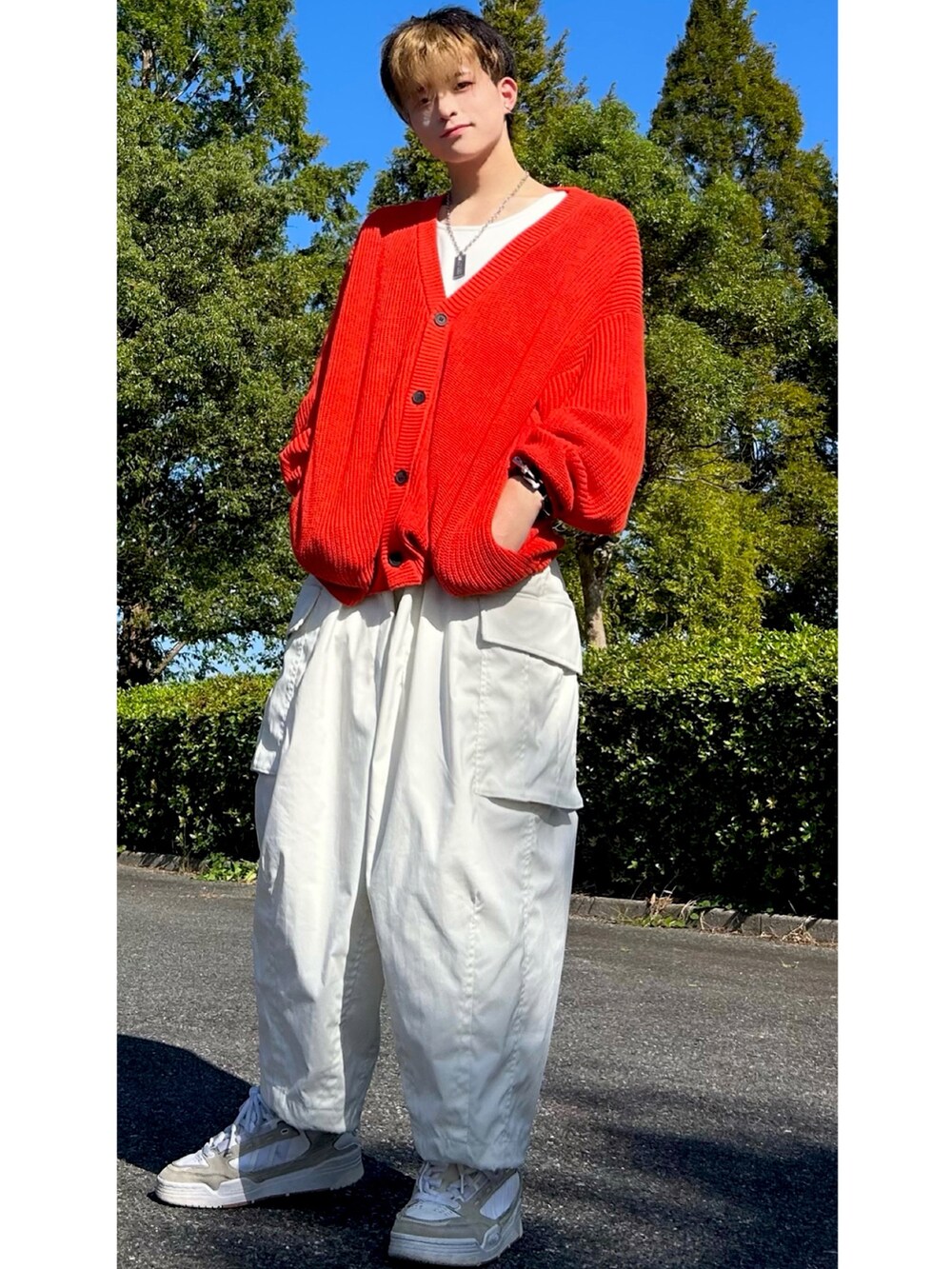 ベージュ系のスニーカー、ホワイト系のカーゴパンツ、オレンジ系のカーディガン/ボレロを着用したメンズの秋コーディネートの2枚目の写真