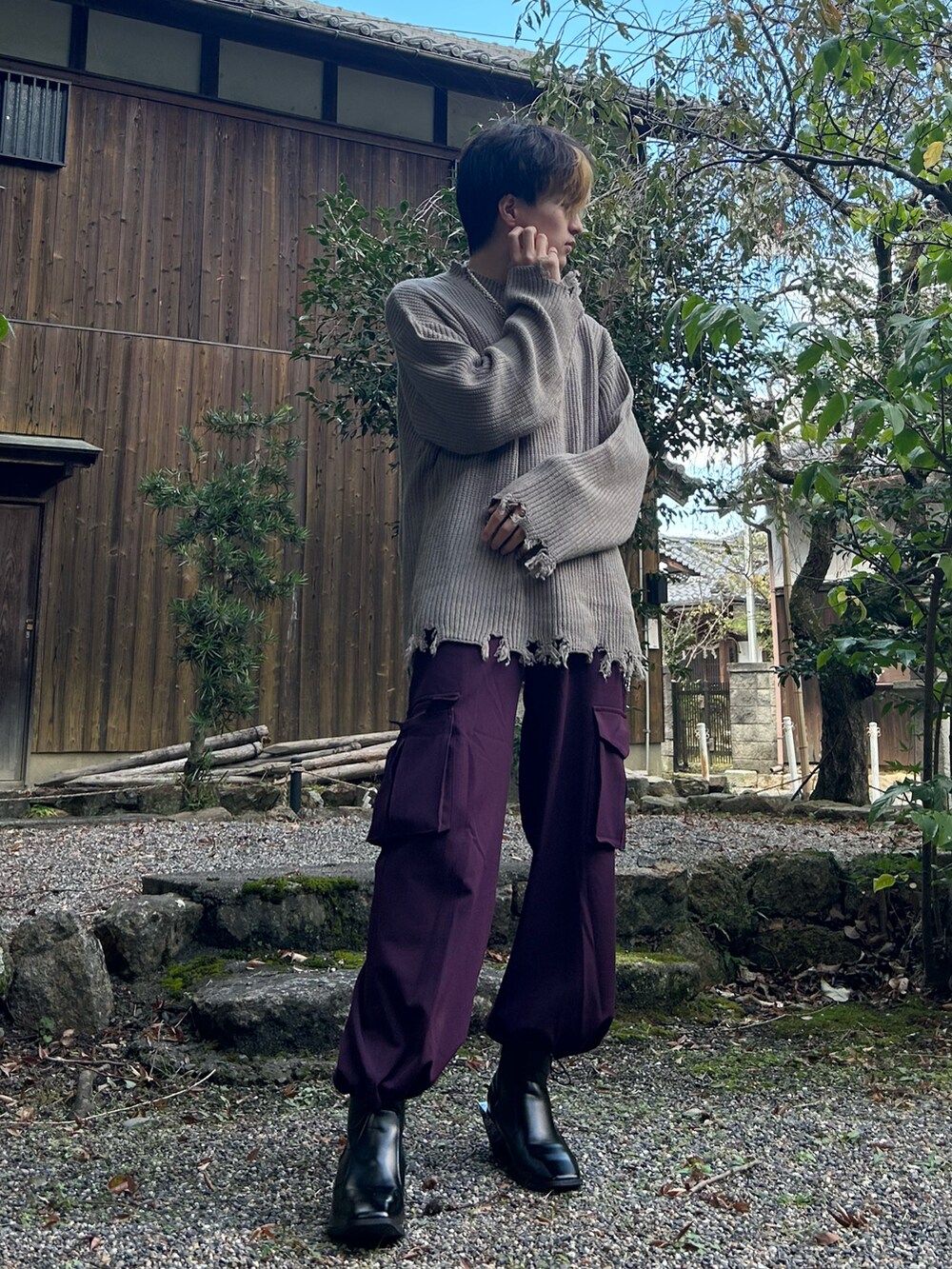 パープル系のカーゴパンツ、ベージュ系のニット/セーター、ブラック系のブーツを着用したメンズの秋コーディネートの3枚目の写真