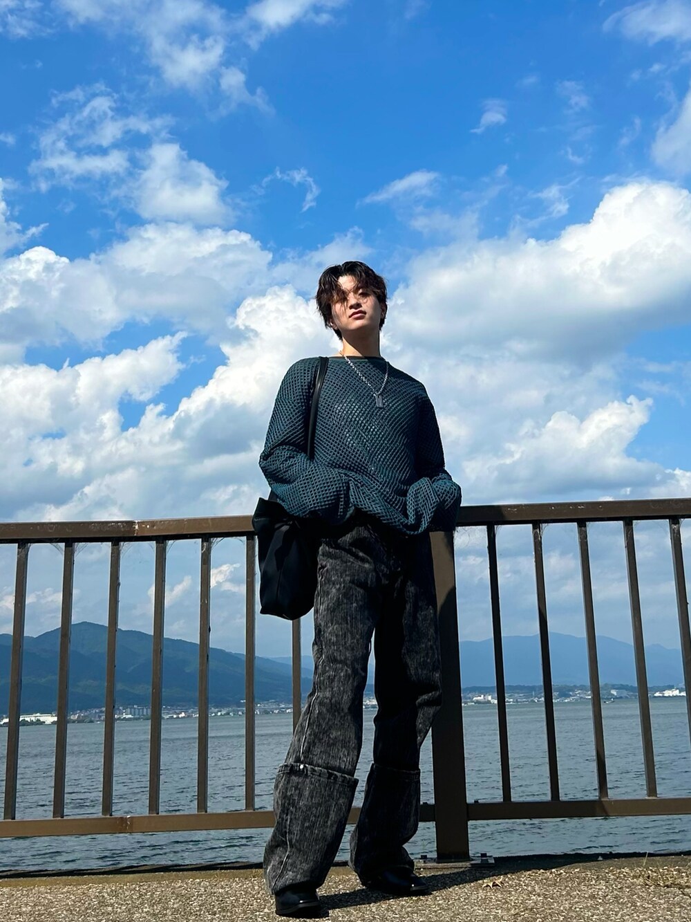 ブラック系のデニムパンツ、ブラック系のブーツ、ブルー系のTシャツ/カットソーを着用したメンズの秋コーディネートの2枚目の写真