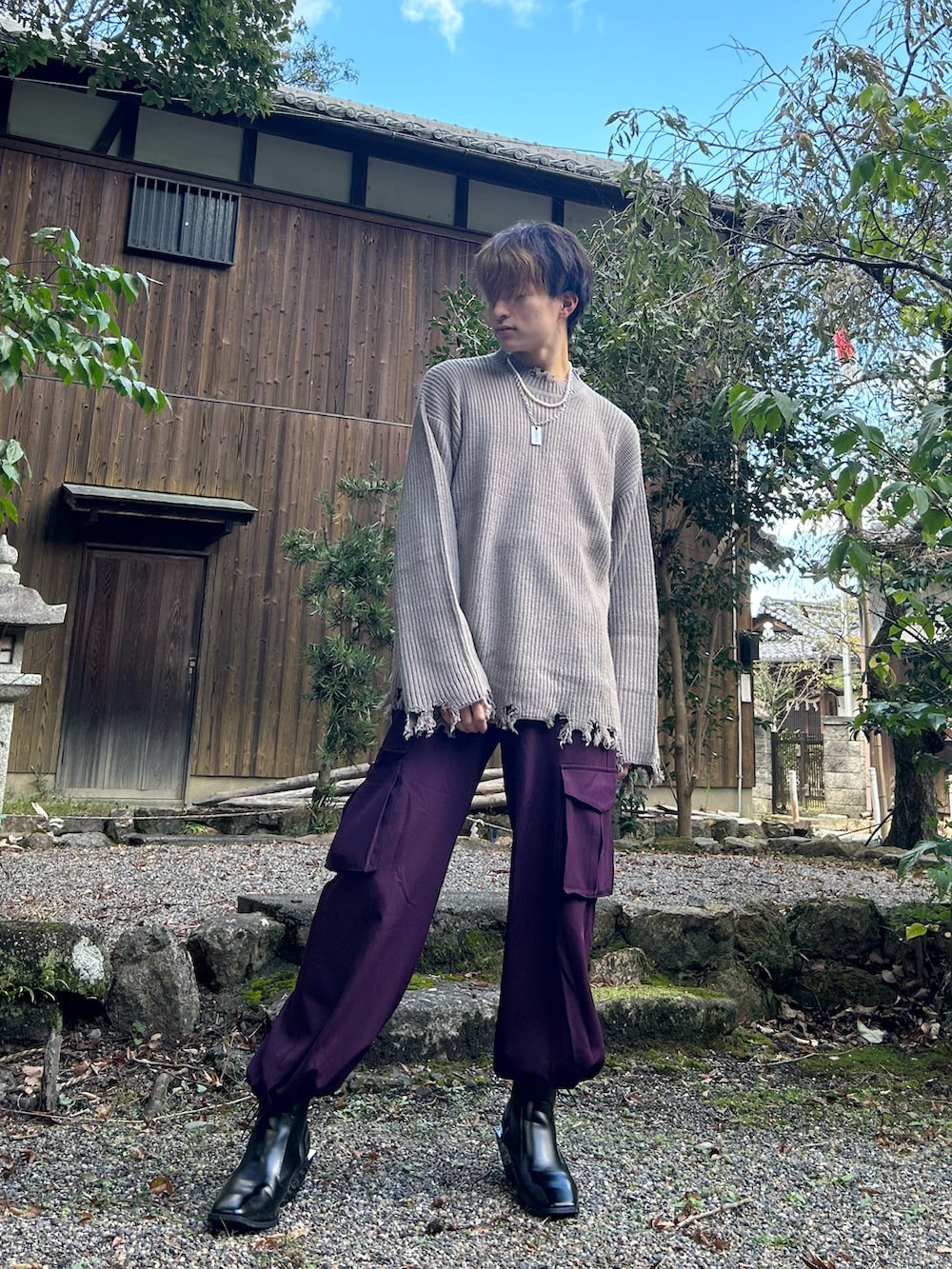 パープル系のカーゴパンツ、ベージュ系のニット/セーター、ブラック系のブーツを着用したメンズの秋コーディネートの2枚目の写真