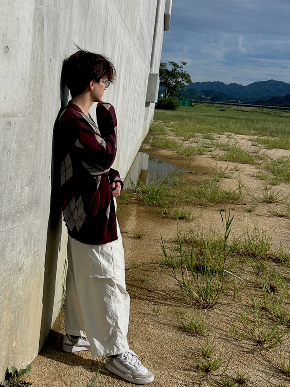 レッド系のカーディガン/ボレロ、ホワイト系のカーゴパンツ、ベージュ系のスニーカーを着用したメンズの秋コーディネートの2枚目の写真