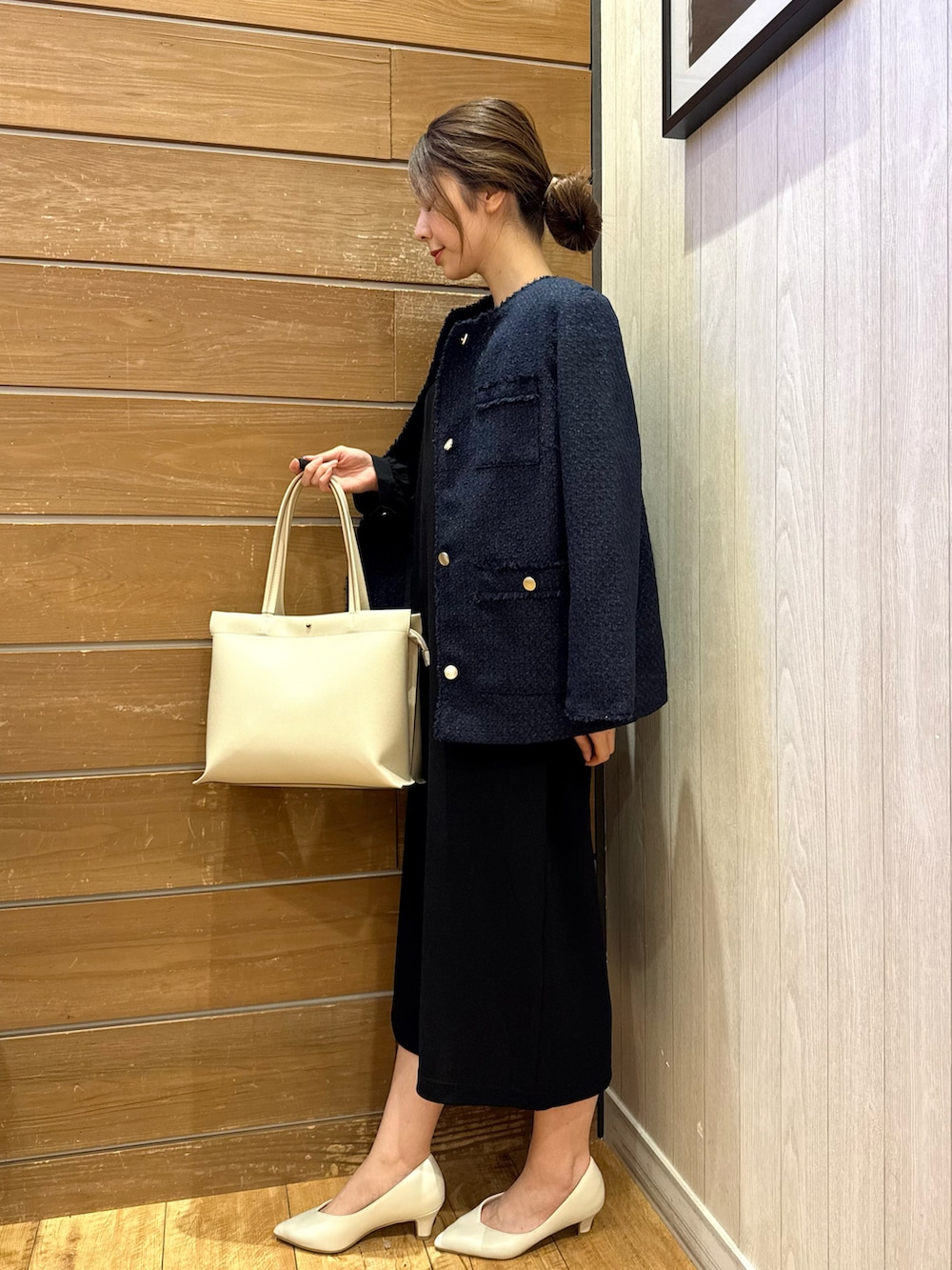 ブルー系のノーカラージャケット、ブラック系のワンピース、ベージュ系のトートバッグを着用したレディースの冬コーディネートの2枚目の写真