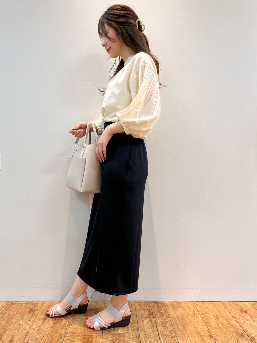 ベージュ系のシャツ/ブラウス、ブルー系のスカート、グレー系のトートバッグを着用したレディースの春コーディネートの2枚目の写真